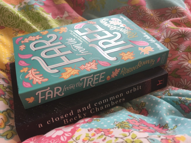 The books Far From the Tree and A Closed and Common Orbit. The cover of Far From the Tree has illustrations of falling leaves.