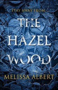 Cover of The Hazel Wood. Illustrations of blue leaves and the text 'Stay away from the hazel wood'